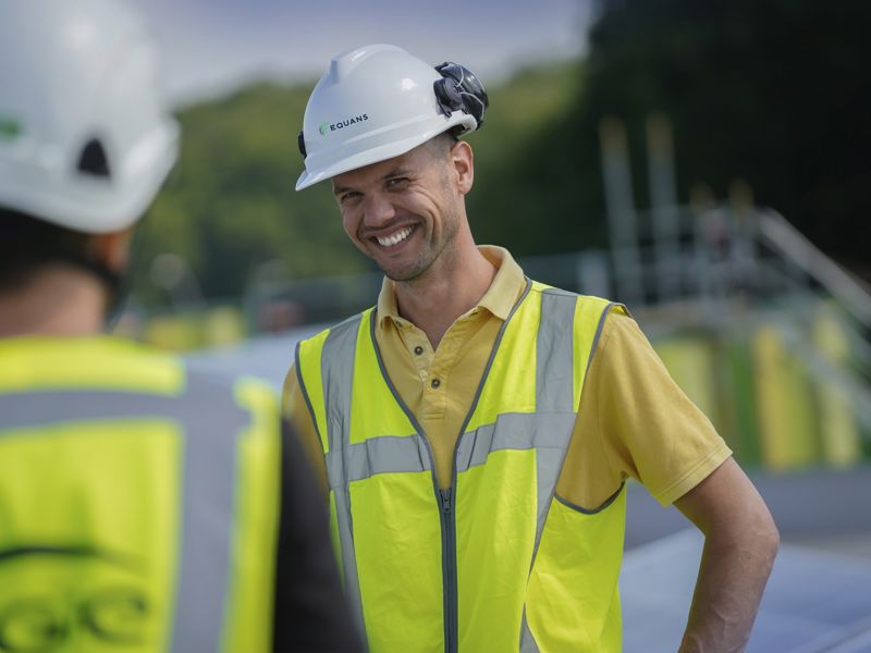 nieuws-equans-circulaire-onderkleding-medewerker-met-helm-en-hesje-lachend-2000x1333.jpg