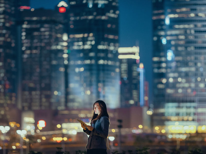 thema-digitalisering-vrouw-met-ipad-nacht-wolkenkrabbers-stad-2000x1012.jpg