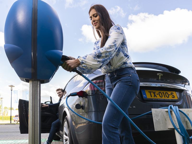 oplossingen-e-mobility-vrouw-met-laadkabel-bij-laadpaal-en-auto-2000x1334.jpg