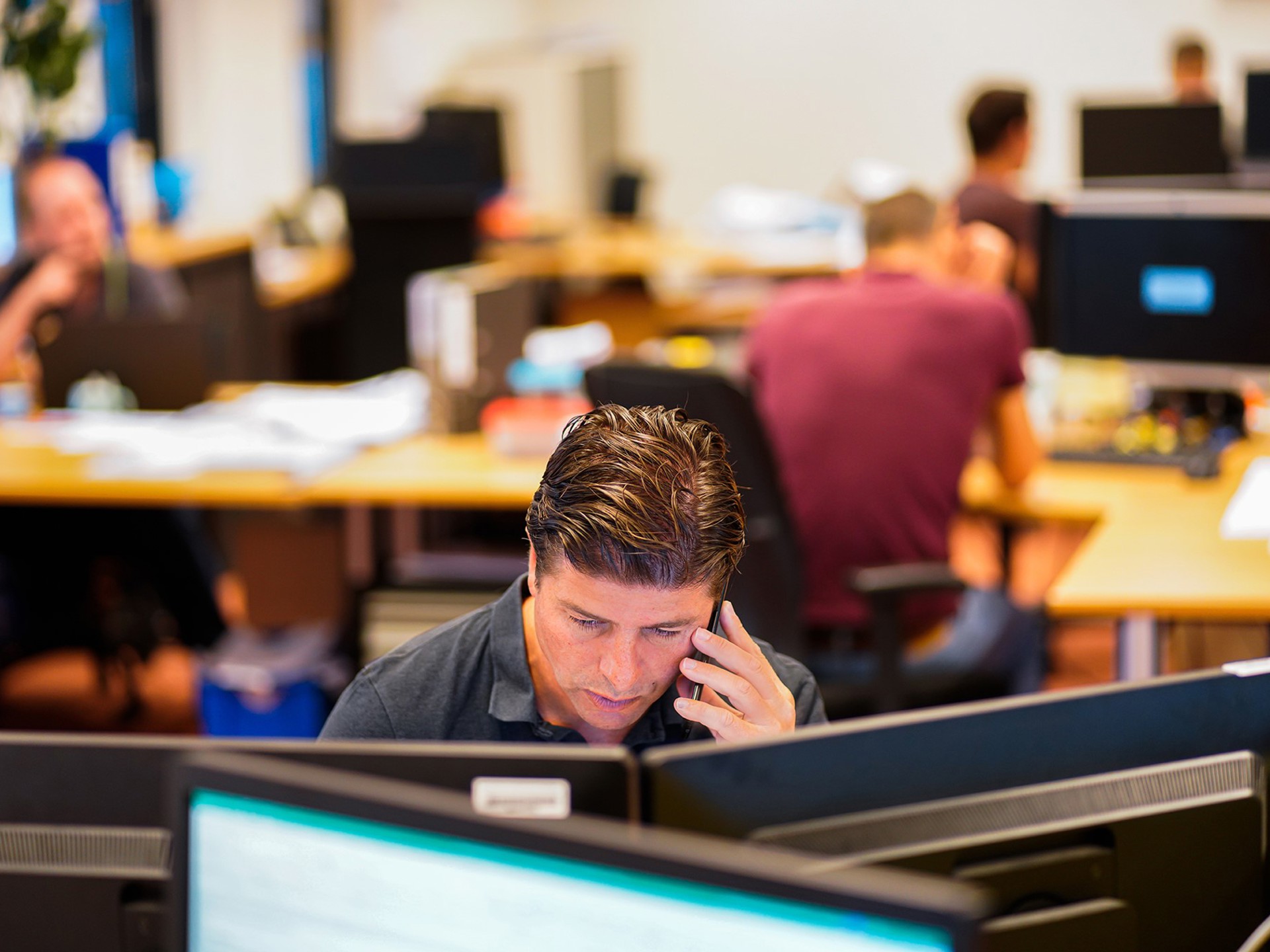 over-ons-contact-medewerker-bellend-achter-computer-2000x1369.jpg